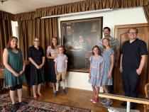 Společné foto rodiny s pracovníky muzea u portrétu J. A. Komenského
